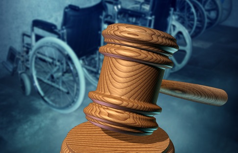 disability law concept - gavel in forground, wheelchairs in back