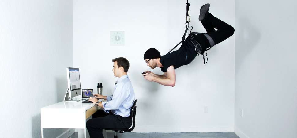 man at computer being watching my man suspended behind him