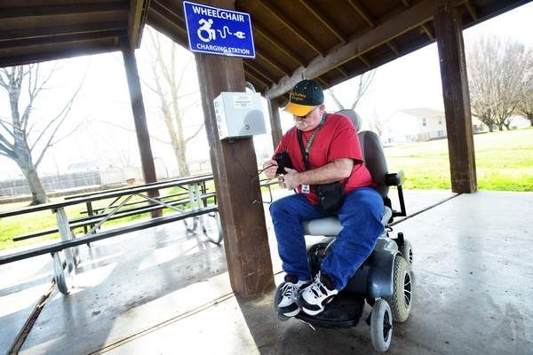 man using mobility device charging station