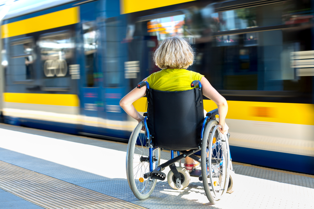 Woman on a wheelchair heading towards a train